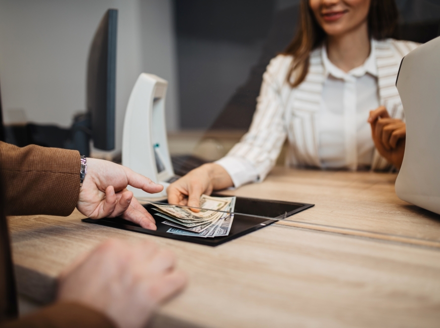 bank teller handing beneficiary money